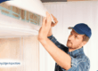 Inspector servicing wall-mounted air conditioning unit.