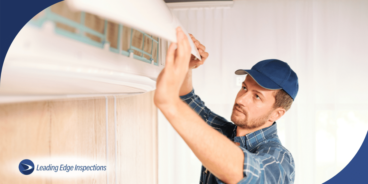 Inspector servicing wall-mounted air conditioning unit.