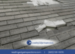 Damaged roof shingles with exposed flashing indicating potential leak risk.