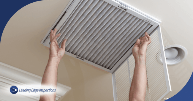Hands replacing home HVAC air filter.