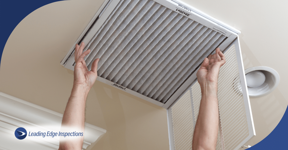 Hands replacing home HVAC air filter.